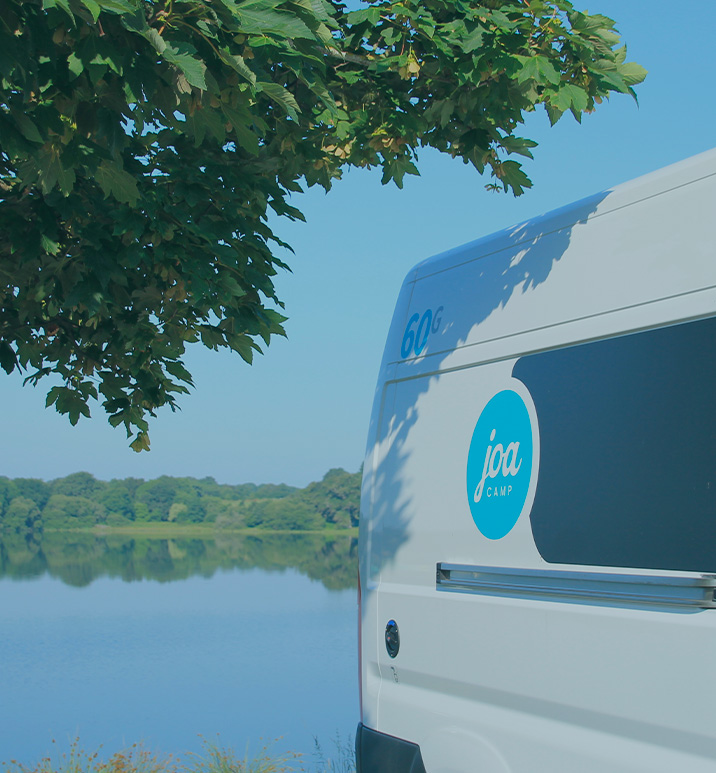 vue sur lac avec un fourgon aménagé joa camp